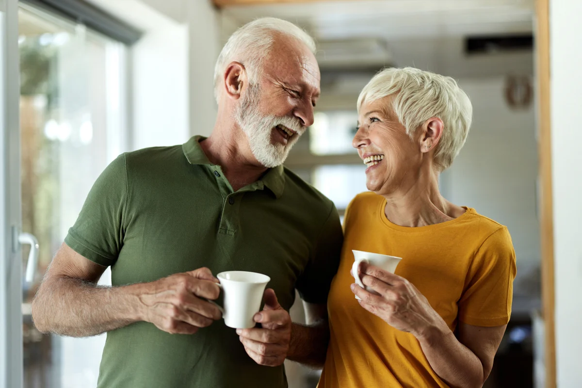 Independent Living in a Friendly, Supportive Senior Community Smiling senior couples enjoying a morning coffee in a vibrant retirement community