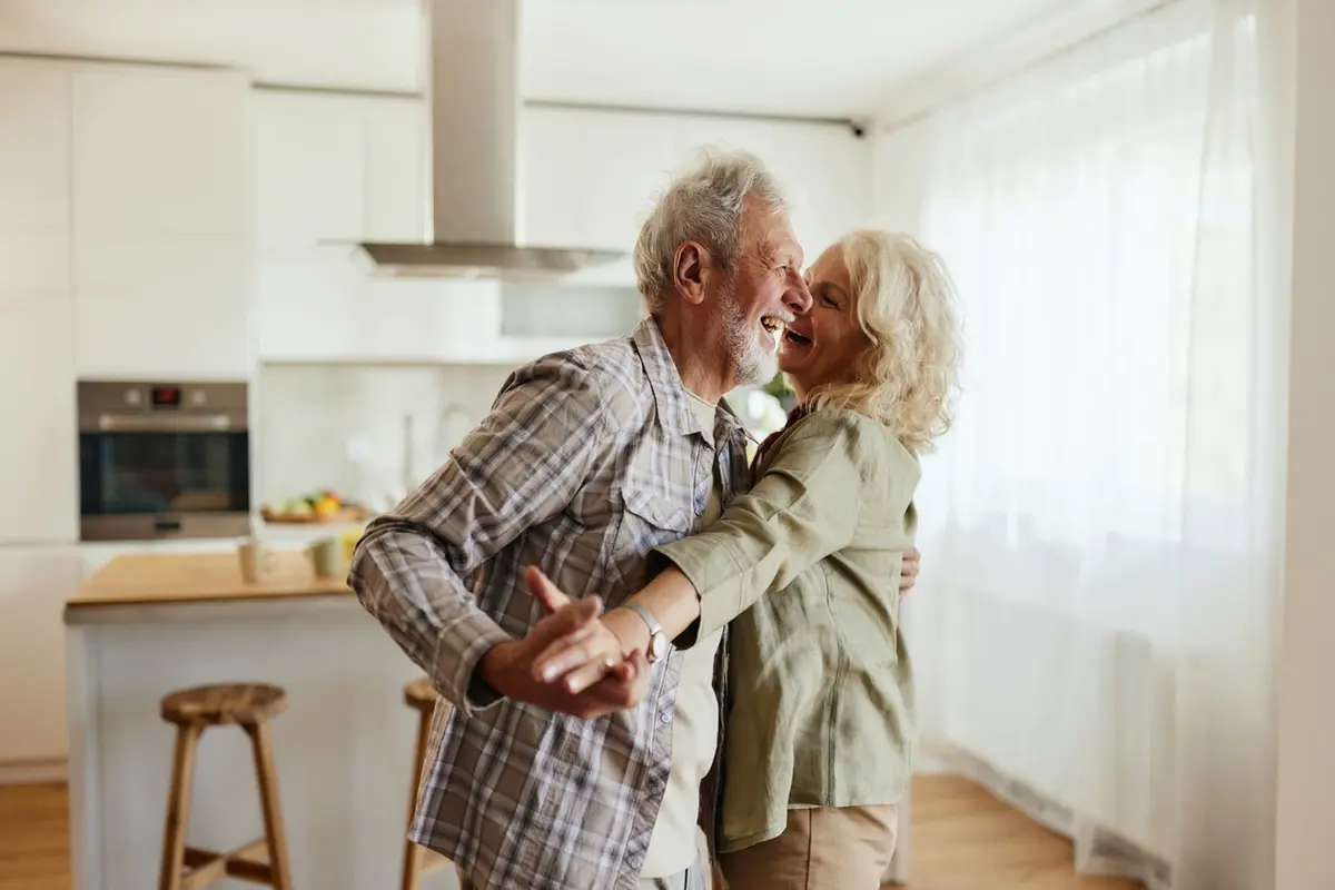 how-to-pay-for-assisted-living-in-prescott Senior couple dancing at home while planning how to pay for assisted living in Prescott