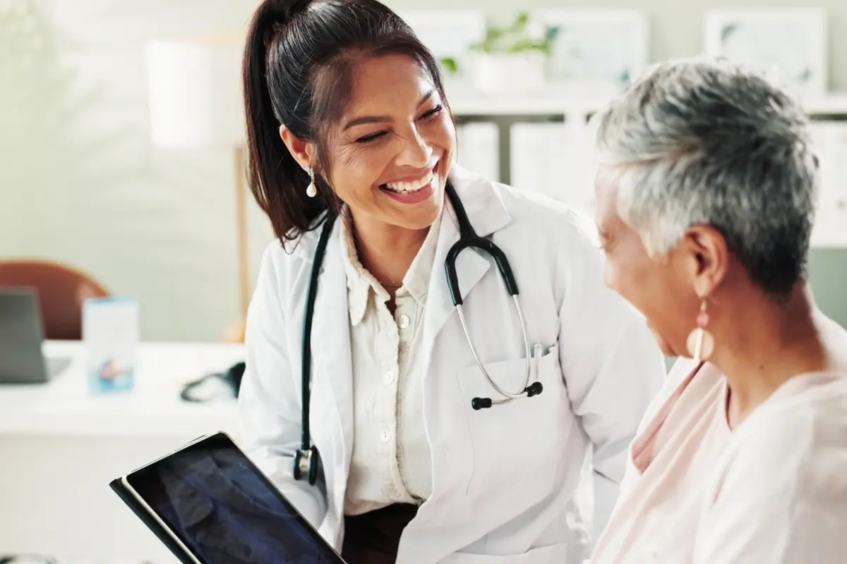 Healthcare in Prescott AZ for Seniors and Families Mature woman doctor using a tablet during a healthcare conversation, representing healthcare in Prescott AZ for seniors considering relocation.