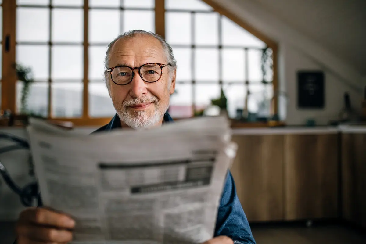 Time To Leave Your Home shown through an older adult sitting at home and considering an important life transition.